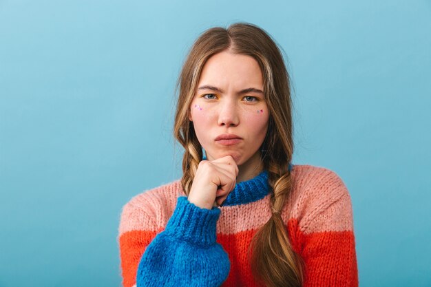 Upset girl wearing sweater standing isolated