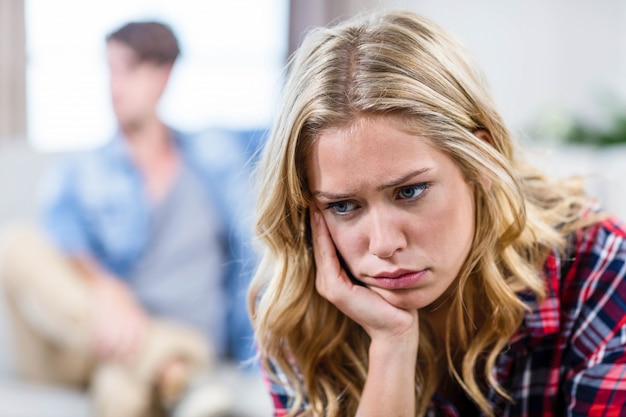 Upset girlfriend sulking her boyfriend in the living room 