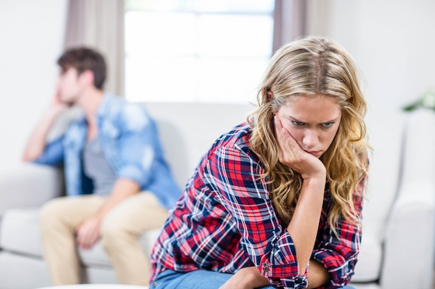 Upset girlfriend sulking her boyfriend in the living room 