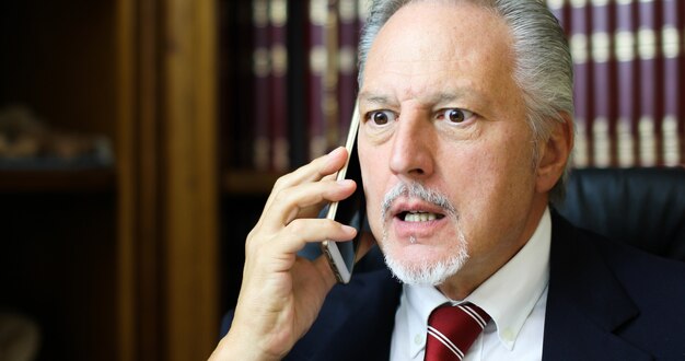 Upset lawyer talking on the phone in his studio