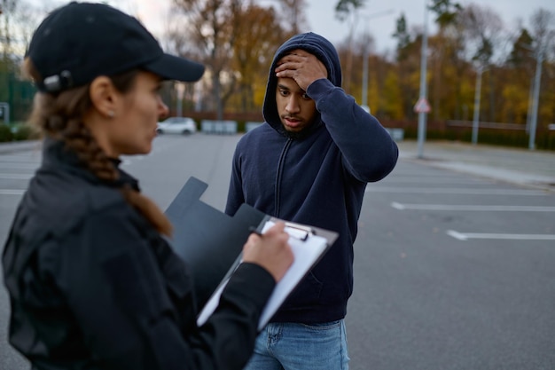 L'uomo sconvolto e la donna della polizia stanno emettendo una multa