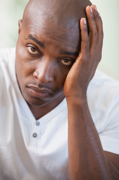 Upset man sitting on the couch looking at camera