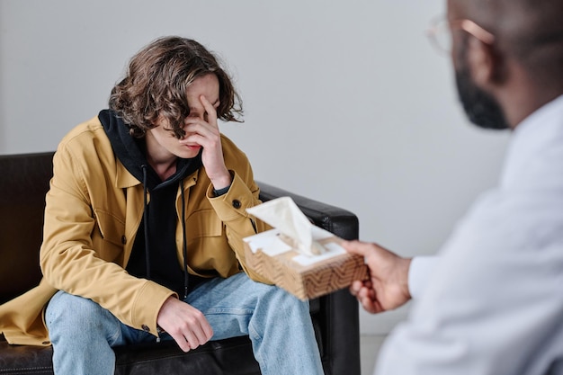 Upset man visiting psychologist at office