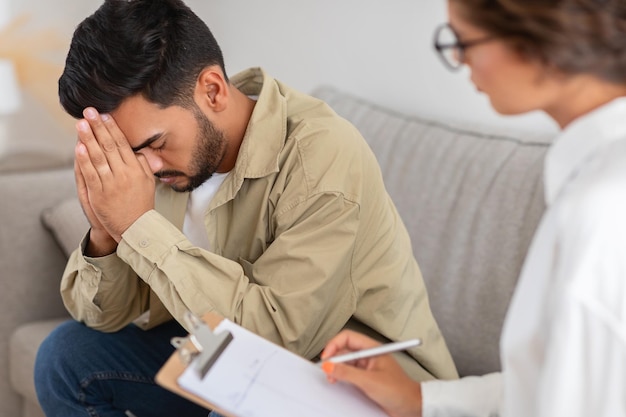 Upset man with hand on forehead therapy