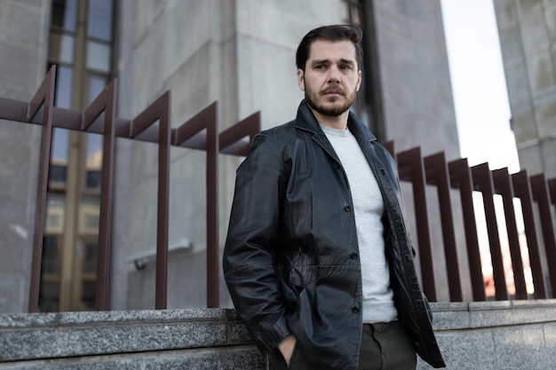 Upset man with a sad expression on the background of a gray building