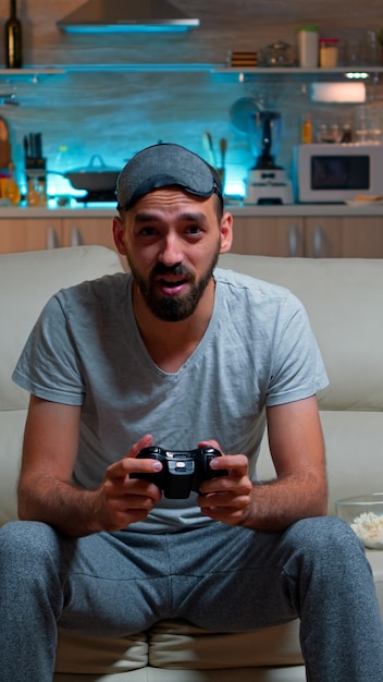 Upset pro gamer sitting in front of television losing soccer\
video games