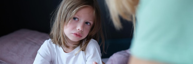 Upset sad little girl communicates with mom at home