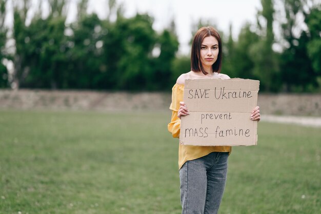 An upset Ukrainian woman protesting against military conflict raises banner No to war Stop Rashism