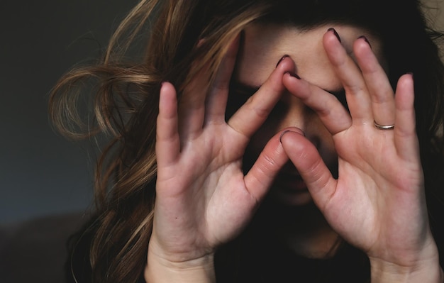 Donna sconvolta si copre il viso con le mani depressione