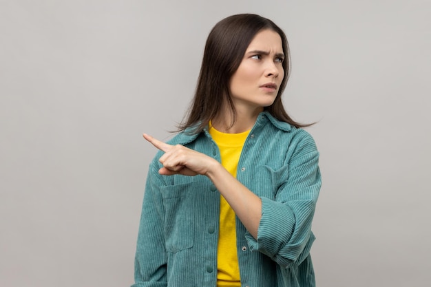 Upset woman showing exit demanding to leave her alone turning away with resentful expression