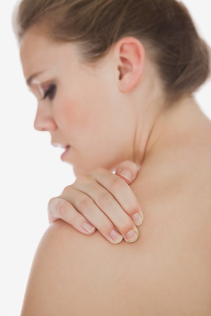 Upset woman suffering from shoulder pain 