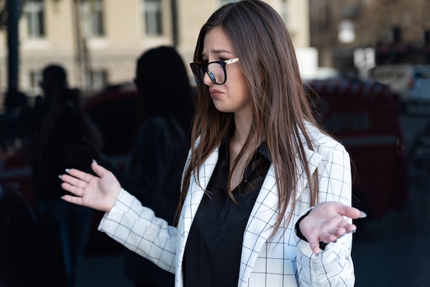 Upset young brunette woman wearing glasses. Failed business negotiations. Beautiful girl is upset about something.