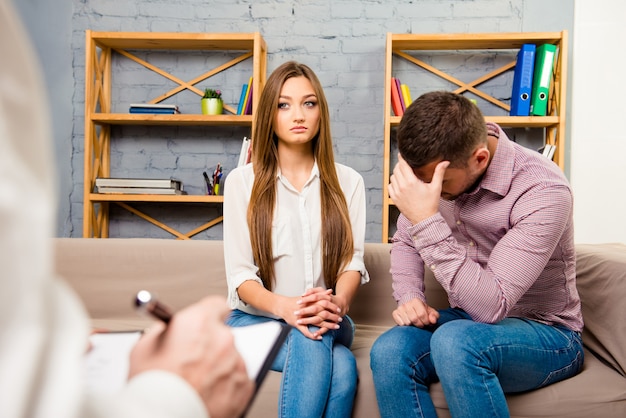 Upset young couple having marital problems in psychotherapist