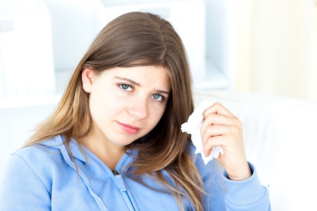 Upset young woman holding a tissue