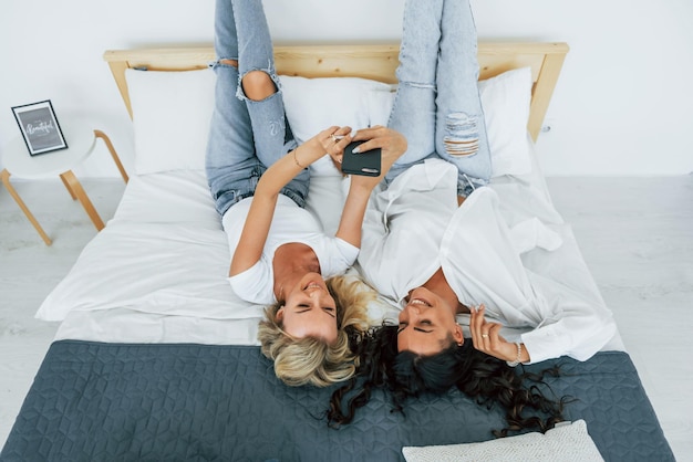 Upside down view laying down on bed two women is together at home