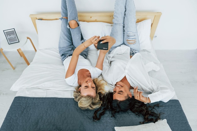 Upside down view Laying down on bed Two women is together at home