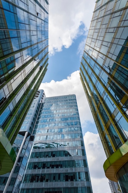 Upward view of modern glass buildings with blue sky