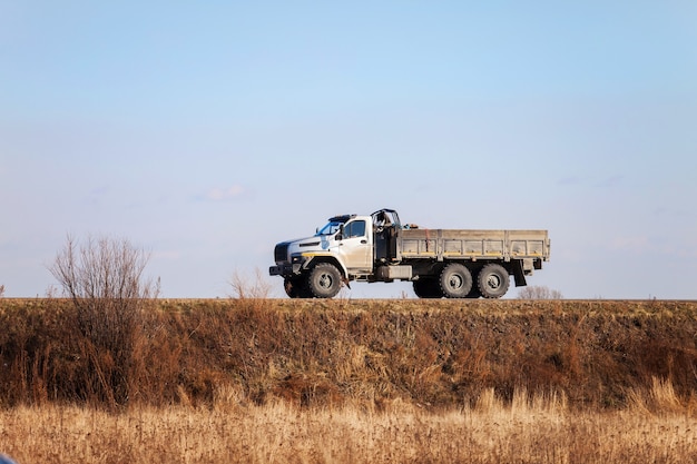 Photo ural next - new russian  off road 6x6 truck on a road in autumn