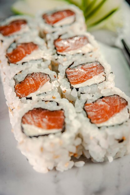 Uramaki salmon on marble plate. Closeup.