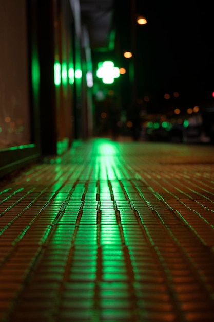 Urban background Lights shadows and reflections in a street Green light reflected on the ground