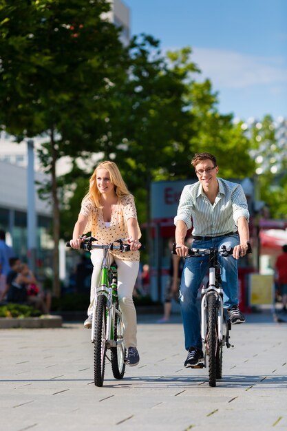 Urban couple riding bike in free time in city