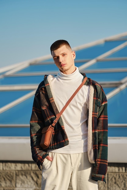 Urban fashion. Young man in loose clothes posing on the street