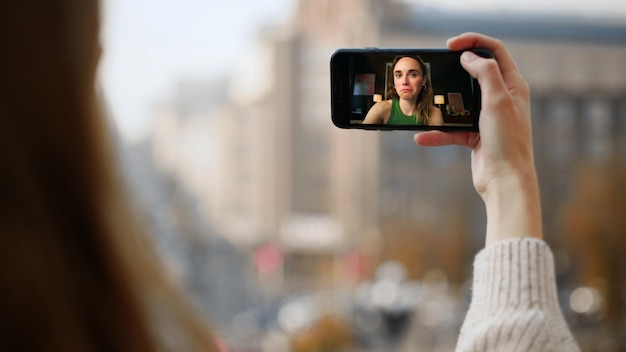Фото Городская девушка разговаривает видео звонок крупный улыбающийся девушка чат на экране смартфона