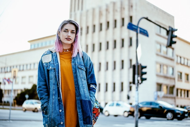 Urban girl with lilac hair at city street.