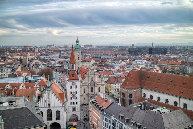 Urban landscape, aerial panoramic view above roofs of retro houses historical part of Munich, Germany on a background of cloudy sunset sky.