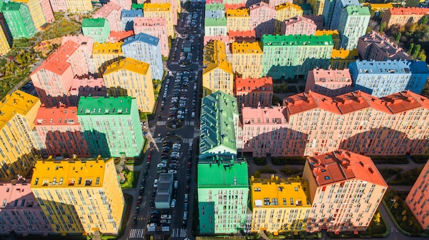 カラフルな建物の都市景観。朝の陽光の下でヨーロッパの都市のカラフルな建物の空撮。色とりどりの家、キエフ、ウクライナの路上で車と街並み