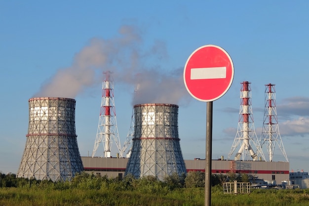 Paesaggio urbano con grandi ciminiere ciminiere e segnale di stop