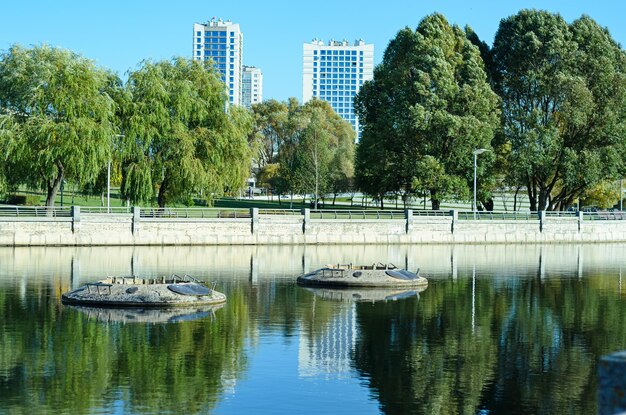 городской пейзаж с деревьями и рекой в солнечный день