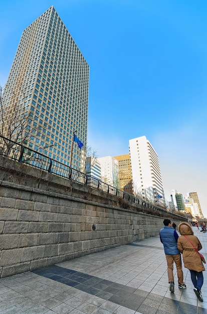 Городской парк на дорожке общественного отдыха Чхонгечхон, Сеул, Южная Корея. Люди, проходящие мимо