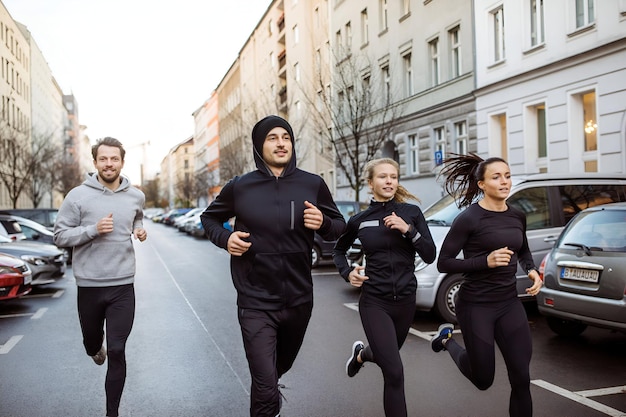 Городские бегуны бегают вместе по городской улице