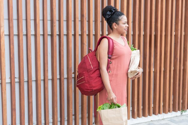 Photo urban shopper woman with groceries and backpack