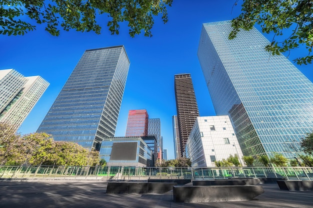 Foto la vista dello skyline urbano da una piazza ombreggiata con alberi