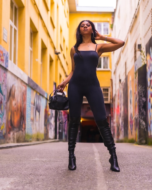 Urban style of a fashionable black girl in a black suit and high boots