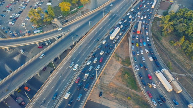 写真 都市交通-都市道路のラッシュアワーの交通。高速道路の道路の交差点を持つ近代的な大都市。大都市での道端の交通渋滞、交通機関の動き。