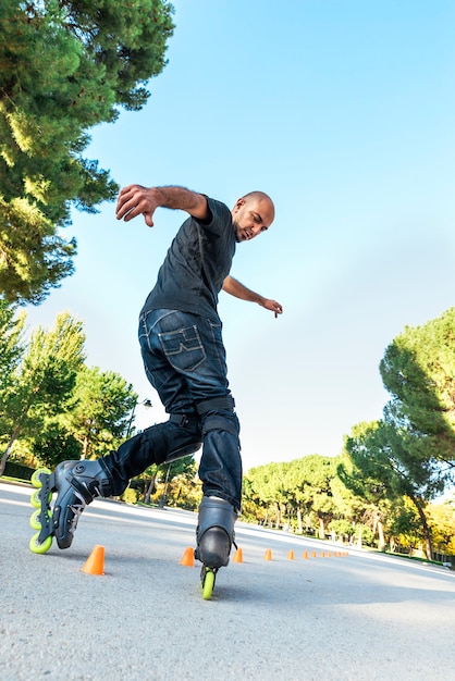 Urban young man on roller skates on the road at summer time. Roller Concept