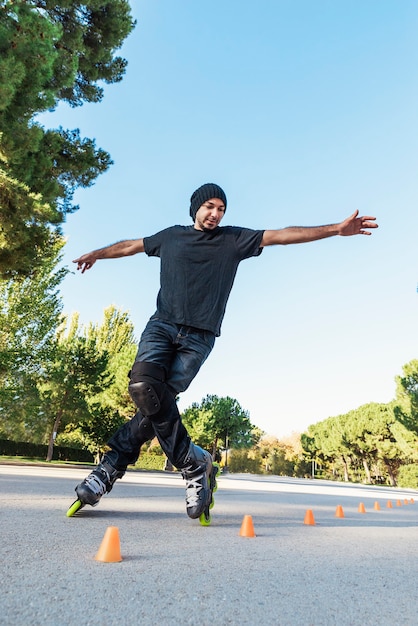 Urban young man on roller skates on the road at summer time. Roller Concept