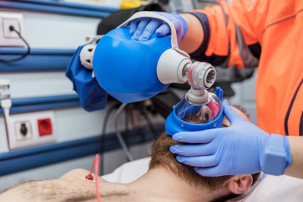 Medico di urgenza che utilizza la borsa di ambu della maschera su un paziente con. insufficienza respiratoria