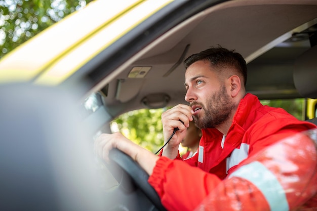 Urgent situation Two young paramedics in ambulance Male caucasian paramedic driving and talking over the radio