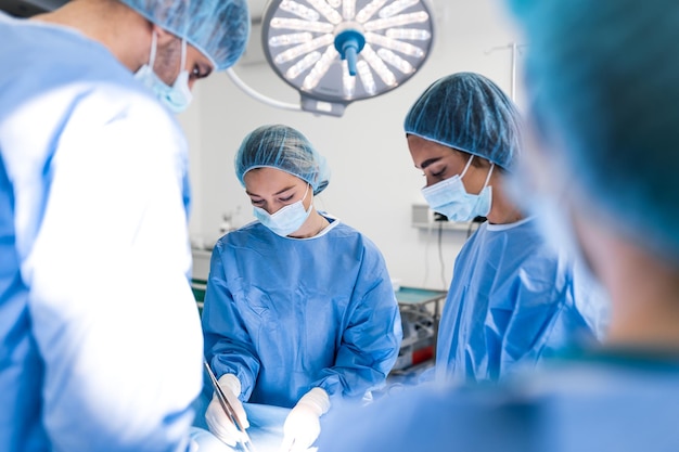 Urgent surgery Professional smart intelligent surgeons standing near the patient and performing an operation while saving his life