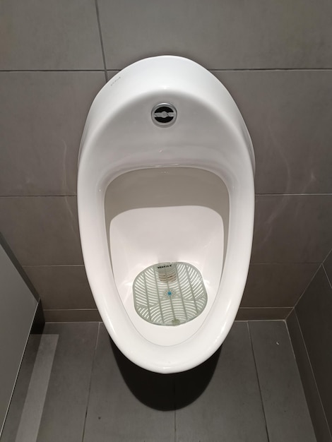 A urinal with a blue button on it