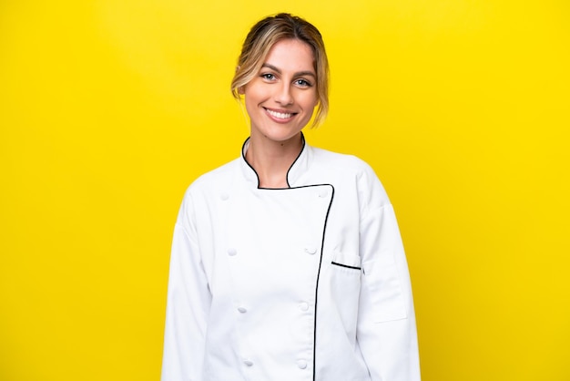 Uruguayan chef woman isolated on yellow background laughing