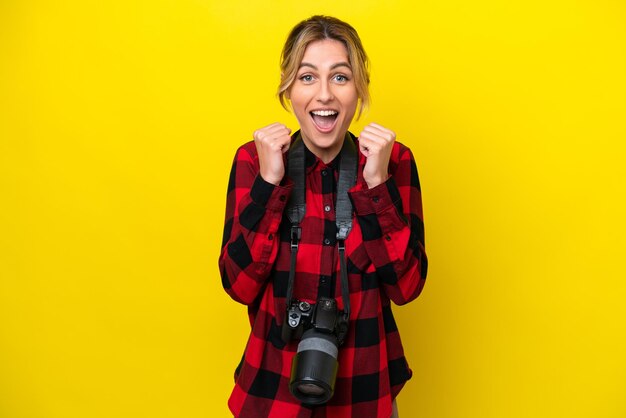 Uruguayan photographer woman isolated on yellow background celebrating a victory in winner position