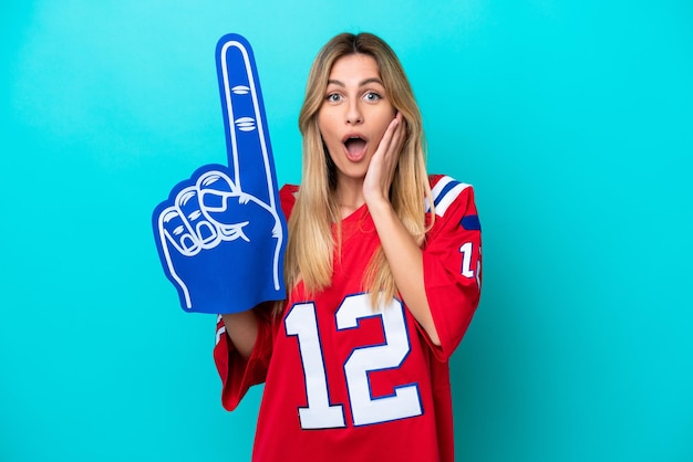 Photo uruguayan sports fan woman isolated on blue background with surprise and shocked facial expression