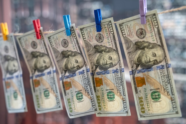 Photo us dollar banknotes hanging on rope with wooden clothespins