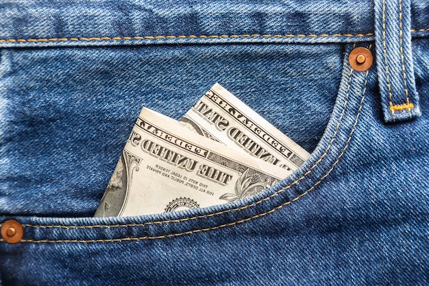 US dollar banknotes in the right front pocket of blue jeans