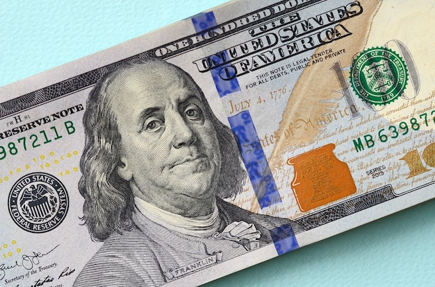 US dollar bills of a new design with a blue stripe in the middle is lies on a light blue